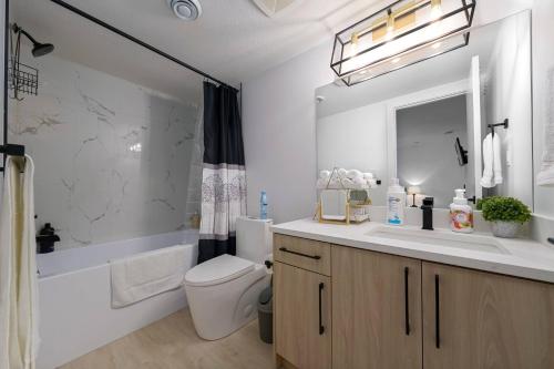 a bathroom with a sink and a toilet and a tub at Modern Suite by Hospital 2 Near Transit, Wi-Fi, Netflix in Edmonton