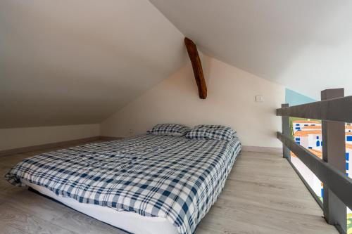 Un dormitorio con una cama con una manta a cuadros. en Le Costa Brava - Hyper centre, en Blois