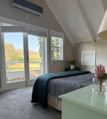 a bedroom with a bed and a large window at Clementine Cottage in Citrusdal
