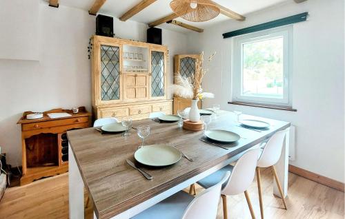 une salle à manger avec une table en bois et des chaises blanches dans l'établissement 3 Bedroom Awesome Home In Zutkerque, à Zutkerque