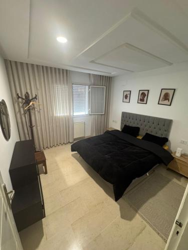 a bedroom with a large black bed in a room at Résidence les jasmins l''aouina in Tunis
