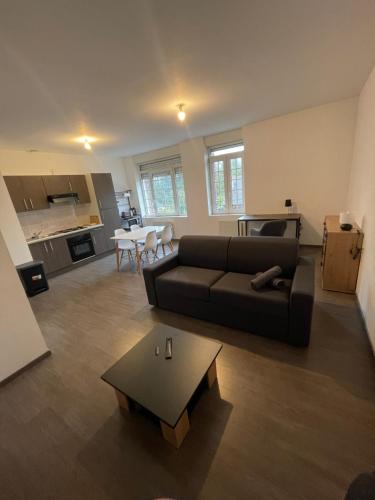 a living room with a couch and a table at Business Apparts Caudry in Caudry