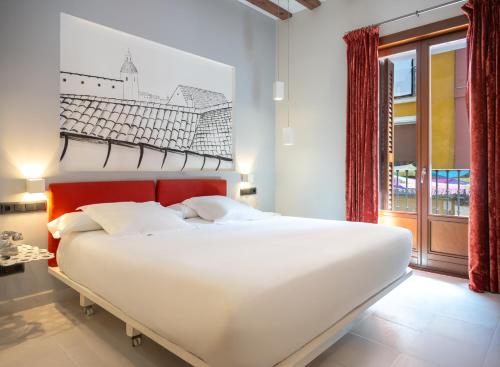 a bedroom with a large white bed and a window at Posada del León de Oro Boutique Hotel in Madrid