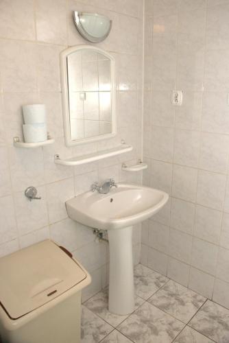 a bathroom with a sink and a toilet and a mirror at Oliwier in Rewal