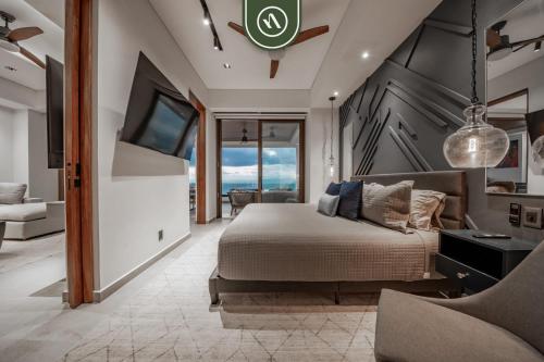 een slaapkamer met een bed en een flatscreen-tv bij Luxury 2 BR Condo with Beachview - Rooftop Pool in Puerto Vallarta