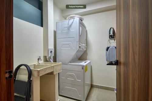 een kleine badkamer met een wastafel en een koelkast bij Luxury 2BR Condo in Nuevo Vallarta - Rooftop Pool in Nuevo Vallarta 