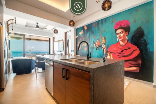 een keuken met een wastafel en een schilderij van een vrouw bij Luxury 2 BR Condo with Beachview - Rooftop Pool in Puerto Vallarta