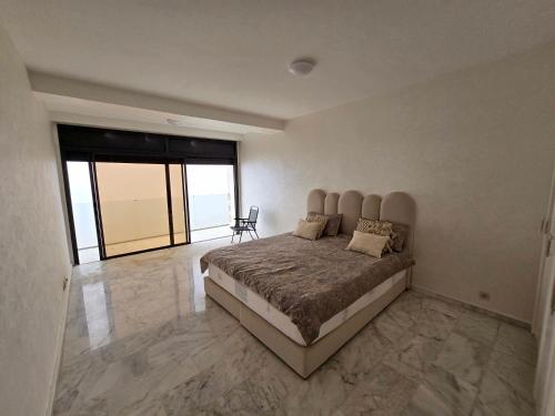 a bedroom with a large bed with a large window at Zaouch house in Moulay Bousselham