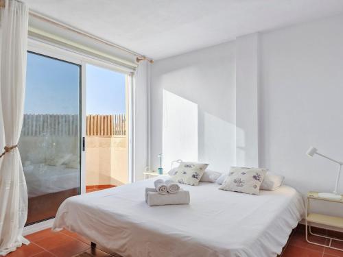 a white bedroom with a bed with a large window at Seaside Home Jacuzzi Pool Free Surf Retreat in El Médano