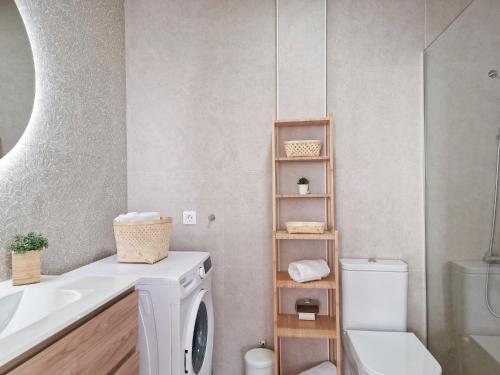 a bathroom with a washing machine and a sink at Seaside Home Jacuzzi Pool Free Surf Retreat in El Médano
