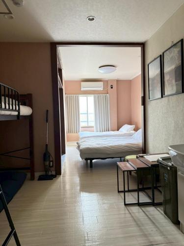 a room with a bedroom with a bed and a mirror at Maison Grand Kishinosato in Osaka