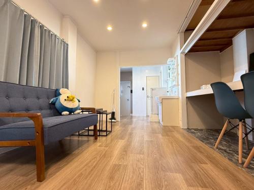 a living room with a blue couch and a table at Maison Grand Kishinosato in Osaka