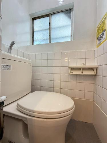 a white toilet in a bathroom with a window at Maison Grand Kishinosato in Osaka