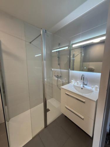 a white bathroom with a shower and a sink at Arcades Hôtel - Cholet in Cholet