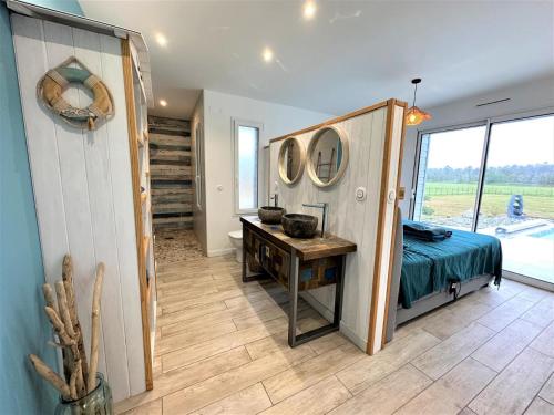 a bedroom with a bed and a desk and a window at Villa nature in Léon