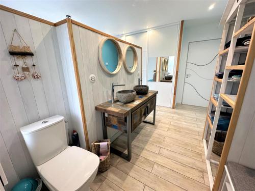 a bathroom with a toilet and a table with a mirror at Villa nature in Léon