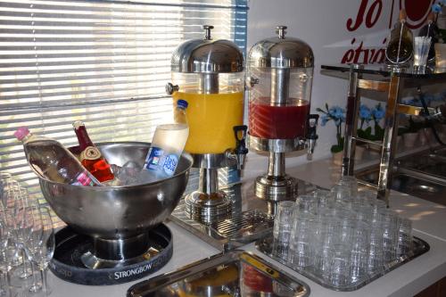 a counter with two bottles and a bowl of drinks at Bükkös Hotel & Spa in Szentendre
