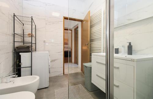 a white bathroom with a sink and a mirror at Apartments Valbandon 1008 in Fažana
