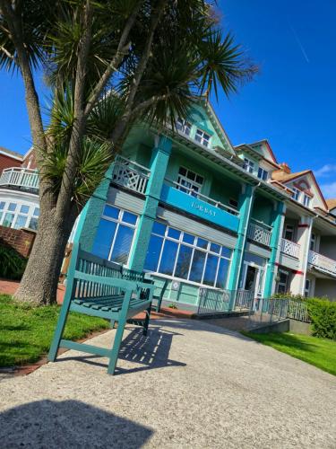 a blue building with a bench in front of it at Beach Hotel Torbay B&B in Paignton