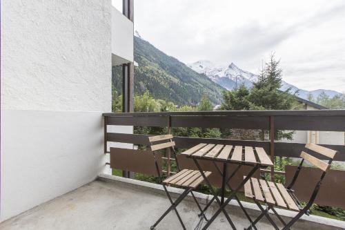 a balcony with a table and chairs and mountains at Résidence Les Periades - Chamonix in Chamonix-Mont-Blanc