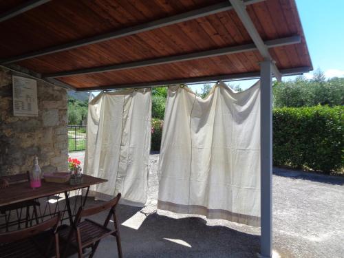 a patio with a table and a white curtain at Il Borgo Agriturismo in Ferentillo