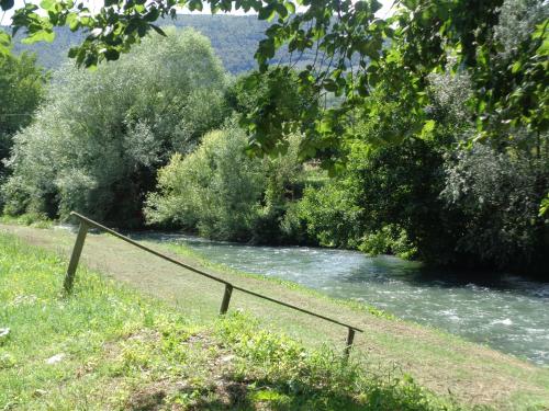 a bridge over a river with trees and a river at Il Borgo Agriturismo in Ferentillo