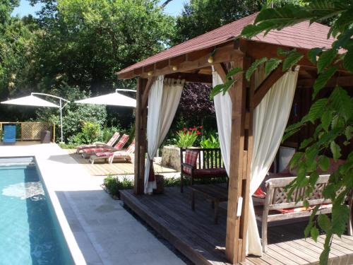 une terrasse en bois avec un kiosque à côté d'une piscine dans l'établissement La Grange Terrou, à Saint-Germain-de-Confolens