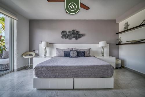 a bedroom with a bed and a clock on the wall at Centric 2BR Condo- Balcony - Rooftop Pool in Bucerías