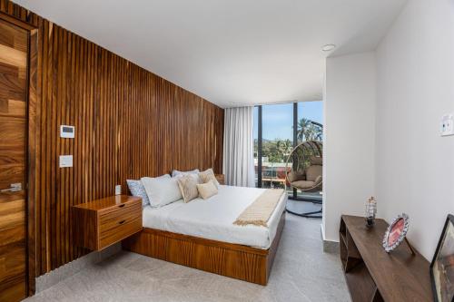 a bedroom with a bed and a wooden wall at Udara udara 2k in Bucerías