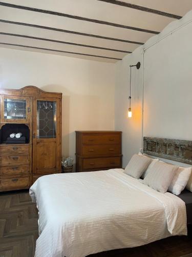 a bedroom with a large white bed and a dresser at Beautiful apartment & garden in Tel Aviv