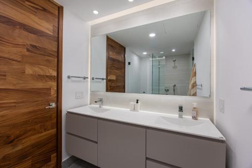 a bathroom with a white sink and a mirror at Udara udara 2k in Bucerías