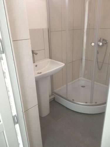 a white bathroom with a sink and a shower at studio with a fireplace in Zugdidi