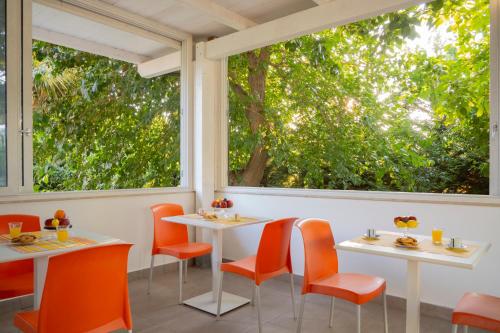 a restaurant with orange chairs and tables and windows at Policaretto Rooms by Calabria Stay in Torretta