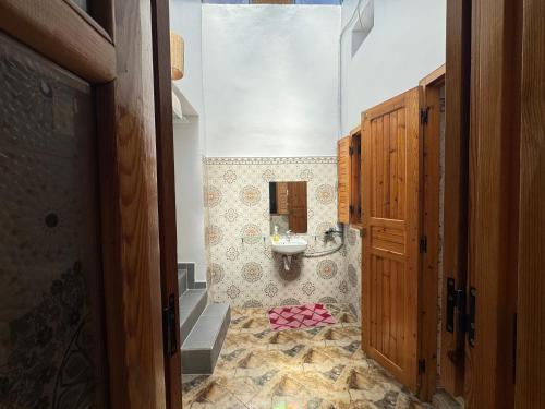 une salle de bain avec un lavabo, des toilettes et un miroir dans l'établissement Dar Lala Haniya, à Rabat