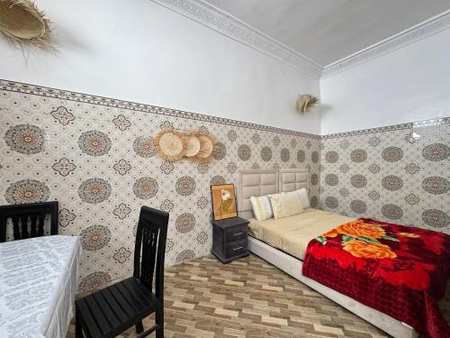 une chambre avec un lit avec un couvre-lit rouge dans l'établissement Dar Lala Haniya, à Rabat