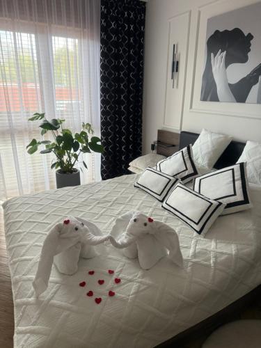 two stuffed elephants are on a bed with roses at Apartament Anna De Lux z tarasem Zamość-Roztocze in Zamość