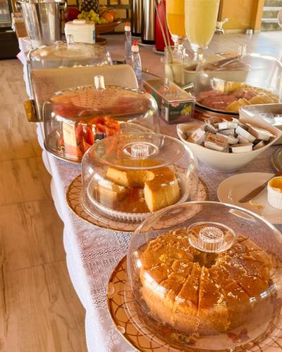uma mesa com várias bandejas de comida sobre ela em Pousada do Rancho em Barreirinhas