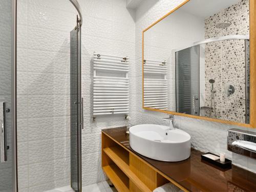a bathroom with a sink and a mirror at Aquaticum Debrecen Termal & Wellness Hotel in Debrecen