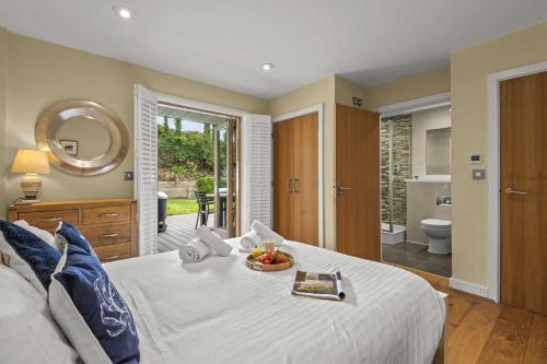a bedroom with a bed with a bowl of fruit on it at House 31 in Looe