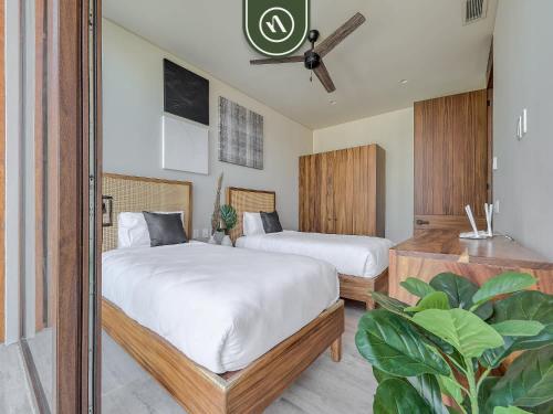 a bedroom with two beds and a mirror at Luxury 4BR Oceanfront Condo - Private Beach - Pool in Cruz de Huanacaxtle