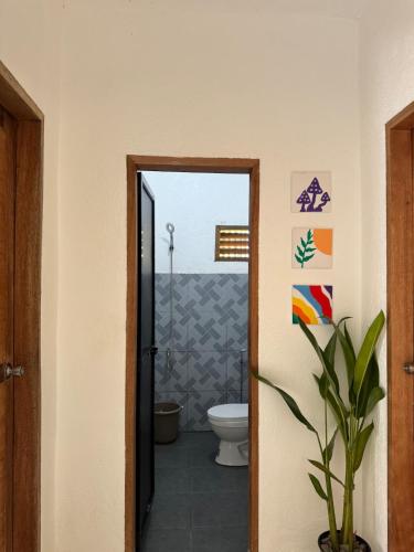 La salle de bains est pourvue de toilettes et d'une porte ouverte. dans l'établissement Casa Ilios - a peaceful 2BR home in Poblacion 5, General Luna, à Catagnan