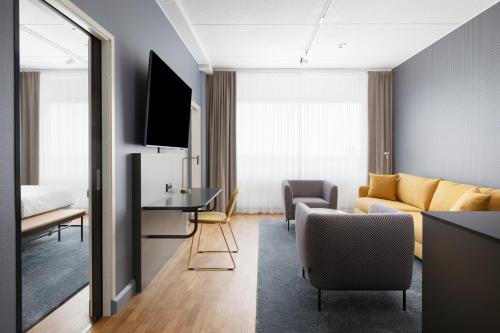 a living room with a couch and a table at Break Sokos Hotel Flamingo in Vantaa