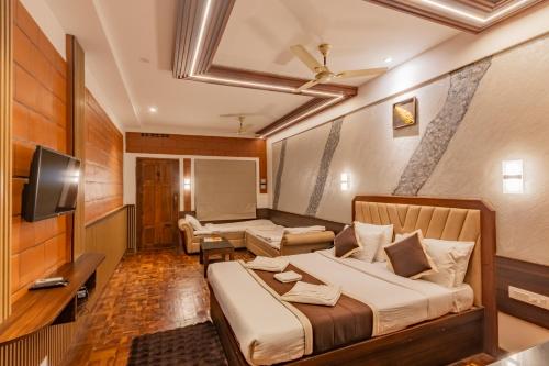 a hotel room with a bed and a tv at The Nest Inn Resort in Masinagudi