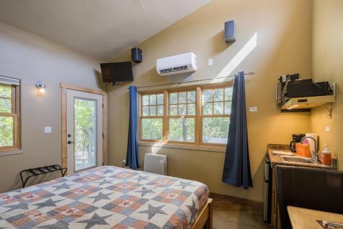 a bedroom with a bed and a sink and a window at Creekside Cowa-Bungalow - 61 E 200 - Studio in Moab