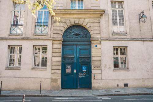 パリにあるMIJE MARAIS Hostelの建物側の青い扉