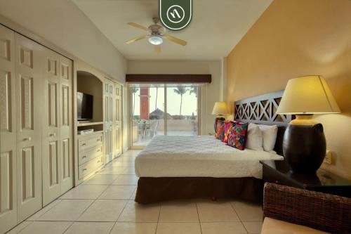 a bedroom with a bed and a ceiling fan at Mexican Styled 2 BR Condo - Beachfront - Pool in Nuevo Nayarit