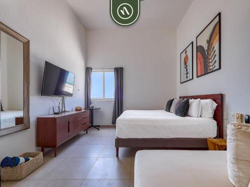 a hotel room with two beds and a television at Cozy Beachfront Studio - Beach Club - Pools in Nuevo Nayarit