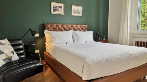 a bedroom with a large bed and a leather chair at Porta Tosa Boutique in Milan