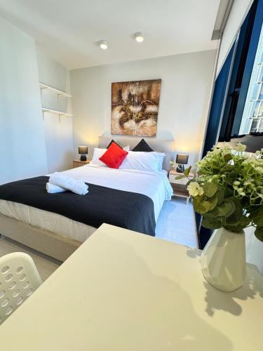 a bedroom with a bed and a table at ADEK Apartments Melb Central-Modern City Escape in Melbourne