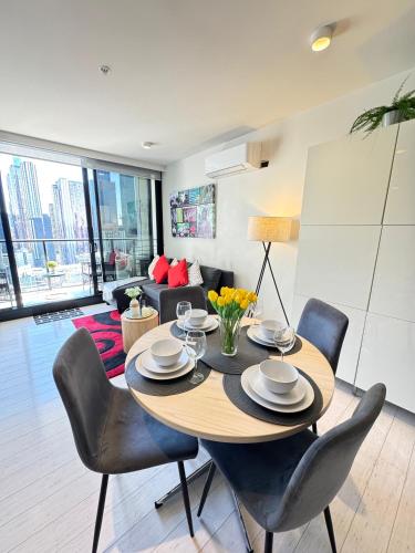 a dining room with a table and chairs in a living room at ADEK Apartments Melb Central-Modern City Escape in Melbourne